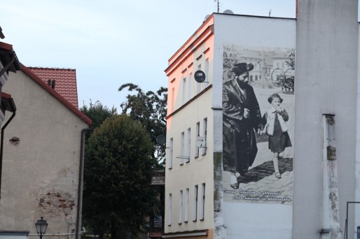Sur les façades des maisons du centre d'Oswiecim, des photos rappellent la vie paisible avant la Shoah. Plus de la moitié de la population était alors de confession juive. Aujourd'hui il n'y a plus aucun juif dans la ville.