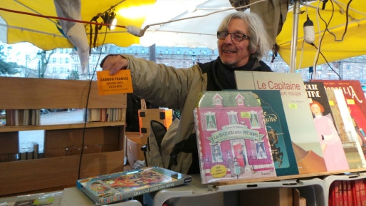 Francis, bouquiniste, a du mal à faire valoir son badge de commerçant pendant le marché de Noël. (Photo CG/cc)