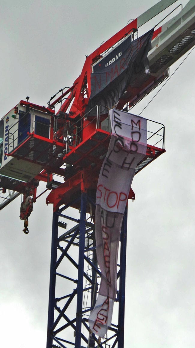 Deux mamans sont montées en haut d'une grue et y ont placé des banderoles affichant les messages "En Marche pour l'école" et " école stop sabotage" (photo RG / Rue89 Strasbourg)