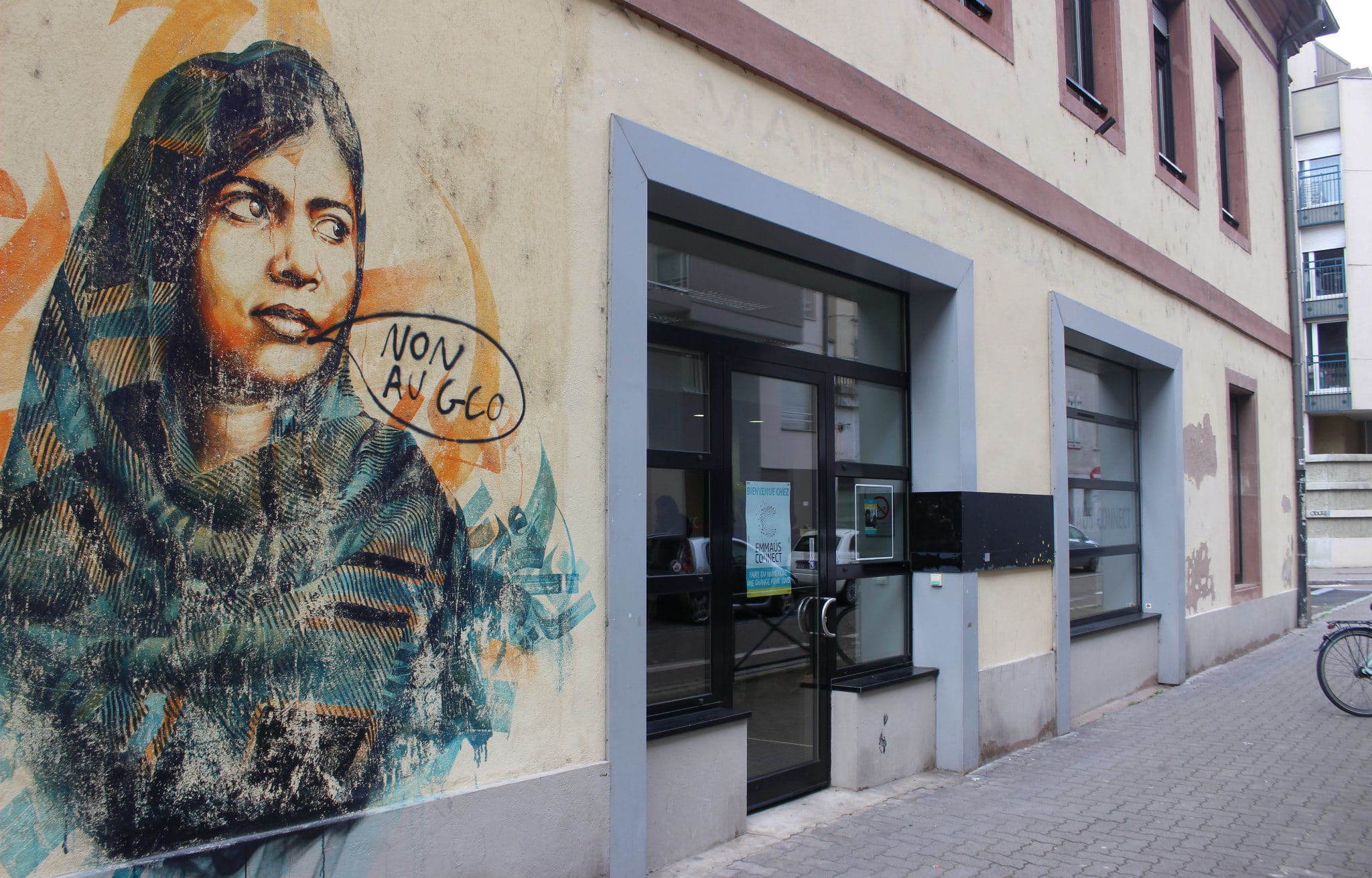 Les lettres de l'ancienne mairie de quartier sous le regard d'une fresque de Dan 23 représentant Malala (auquel un autre tag s'est ajouté) (photo JFG / Rue89 Strasbourg)